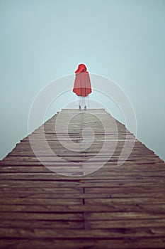 Red hood woman in a misty pier