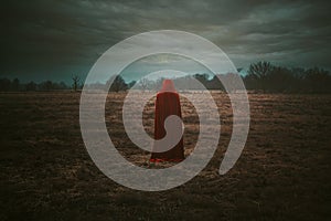 Red hooded person in a desolate moorland