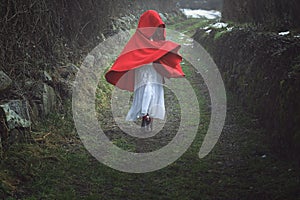 Red hooded woman on a dark country road