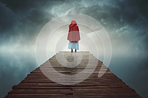 Red hooded woman lost in a surreal land