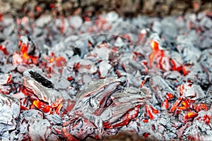 Red-hot charcoal in the hearth close-up. The concept of home comfort and warmth, alternative energy sources and ecology.