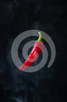 Red Hot Chili Pepper Levitation in the Air with Smoke on Black Background
