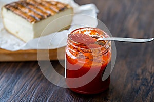 Red Hot Chili Pepper Sauce for Artisan Cheese made with Vinegar and Sugar in Glass Bowl with Spoon