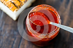 Red Hot Chili Pepper Sauce for Artisan Cheese made with Vinegar and Sugar in Glass Bowl with Spoon