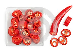 red hot chili pepper slices in ceramic bowl isolated on white background. Top view. Flat lay.