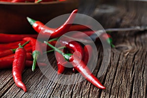 Red hot chili pepper on vintage silver fork over red background