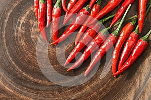 Red hot chili peppers on brown clay flat plate. Food background