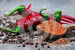 Red hot chili peppers and a mixture of different peppers on a wooden table. traditional spices.