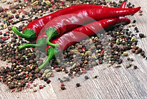 Red hot chili peppers and a mixture of different peppers on a wooden table. traditional spices.