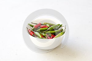 Red Hot Chili Peppers On Modern Background or White Table, on a Round Bowl. A Lot of Red Chilli Peppers. Green Hot Chili Peppers.