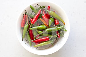 Red Hot Chili Peppers On Modern Background or White Table, on a Round Bowl. A Lot of Red Chilli Peppers. Green Hot Chili Peppers.