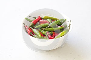 Red Hot Chili Peppers On Modern Background or White Table, on a Round Bowl. A Lot of Red Chilli Peppers. Green Hot Chili Peppers.