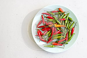 Red Hot Chili Peppers On Modern Background or White Table, on a Round Plate. A Lot of Red Chilli Peppers. Green Hot Chili Peppers