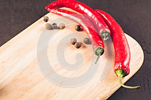 Red hot chili peppers and spices on a empty cutting board/ Red hot chili peppers and spices on a empty cutting board. Copy space