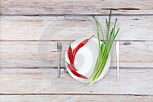 Red hot chilli pepper and scallions on plate
