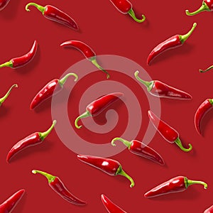 Seamless pattern made of red chili or chilli on red background. Minimal food pattern. Red hot chilli seamless peppers pattern.