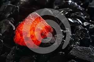 Red hot coal nugget on focus on other cold raw nuggets of coal. Background of raw coals with soft focus exclusion with color and t photo