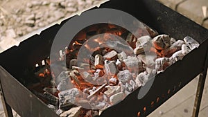 Red hot coals slowly smolder in the grill. Smoke and ash rise up. Grilling