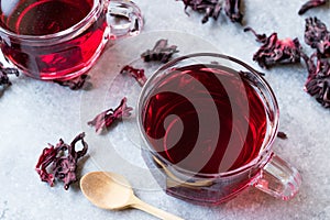 Red Hot Hibiscus Tea in White Cup with Dried Hibiscus Tea Leaves.