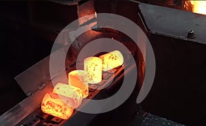 A red-hot metal ingots on a rolling mill at a metallurgical plant.