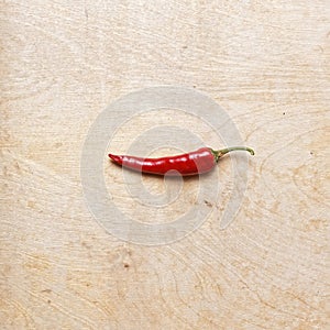 Red hot pepper on wooden table with place for text