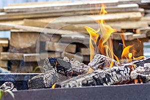 Red-hot pieces of coal and flames in a cooking brazier.