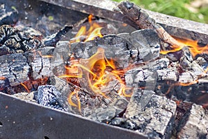 Red-hot pieces of coal and flames in a cooking brazier.