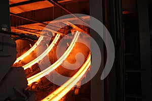 Red hot steel metal billets after molten steel casting.  Continuous casting machine. Background of the blacksmith and photo