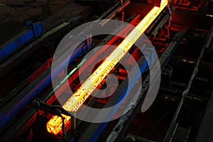 Red hot steel metal billets after molten steel casting.  Continuous casting machine. Background of the blacksmith and