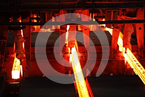 Red hot steel metal billets after molten steel casting.  Continuous casting machine. Background of the blacksmith and