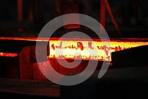 Red hot steel metal billets after molten steel casting.  Continuous casting machine. Background of the blacksmith and
