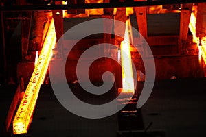 Red hot steel metal billets after molten steel casting.  Continuous casting machine. Background of the blacksmith and