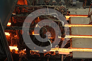 Red hot steel metal billets after molten steel casting.  Continuous casting machine. Background of the blacksmith and