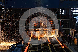 Red hot steel metal billets after molten steel casting.  Continuous casting machine. Background of the blacksmith and