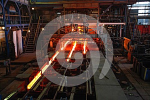 Red hot steel metal billets after molten steel casting.  Continuous casting machine. Background of the blacksmith and