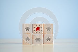 Red house icon on wooden block with focus frame. Decision for buy or rent home.