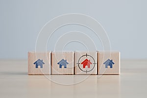 Red house icon on wooden block with focus frame. Decision for buy or rent home.