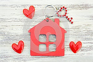 Red house shaped keychain with a key and hearts