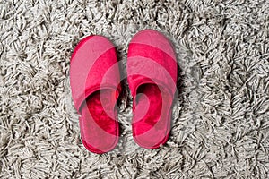 Red house slippers on gray carpet