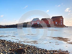 Red houses of the fishing village. Traditional red white building in small port, coastline of cold north sea