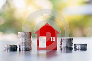 Red houses and a pile of coins. Home based loan ideas. Money from business finance coins. Successful financial business. Savings