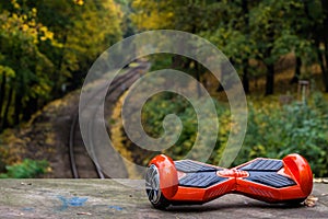 Red hoverboard against the background of railroad rails