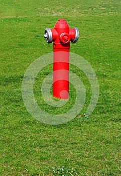 Červený hydrant a zelená tráva jako pozadí