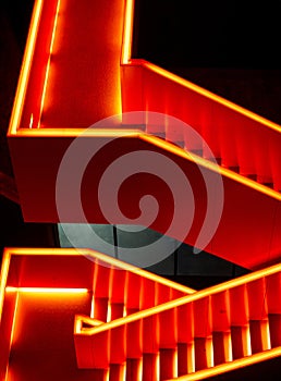 Red illuminated metal staircase at night on the industrial site