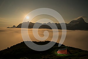 Red illuminated tent during night time in the mountains