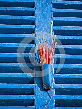 Red Incense on Blue Window Shutters