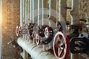 Red industrial old valves in a row on brick wall