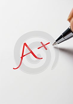 A+ Grade being written in red on papersheet.