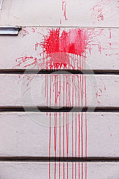 Red ink splashes on a wall