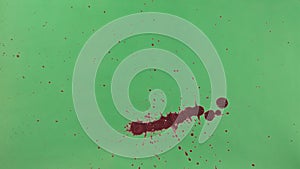 Red Ink Splatter Over Green Screen Background